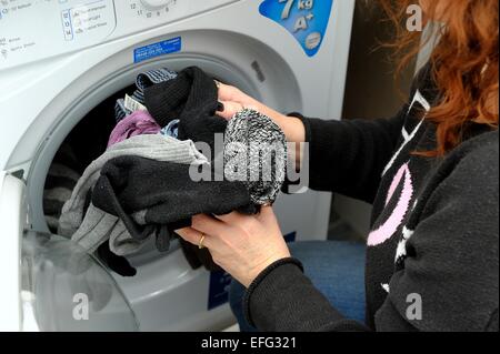 Une femme dépose d'un sèche-linge à laver Banque D'Images