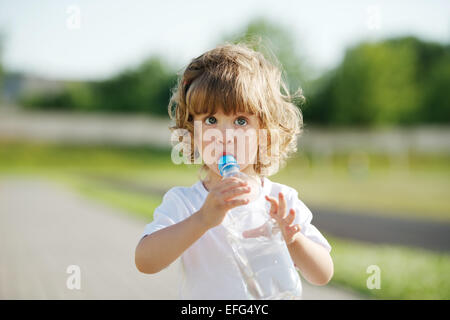 Petite fille de boire de l'eau de bouteille en plastique Banque D'Images