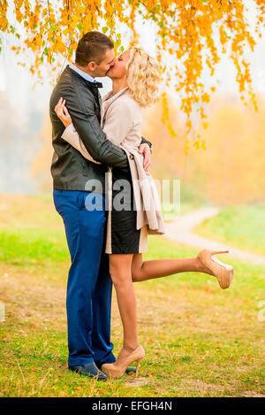 A Loving couple kissing in autumn park Banque D'Images