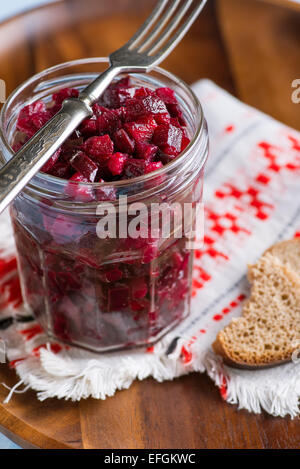 Salade de betterave russe dans un bocal en verre sur plateau en bois, fourchette et le pain de seigle, selective focus Banque D'Images