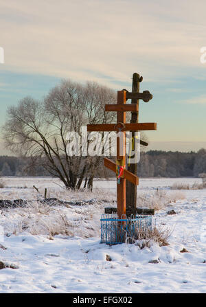 Croix de l'église orthodoxe dans le coucher du soleil lumière contre willow tree en hiver Banque D'Images