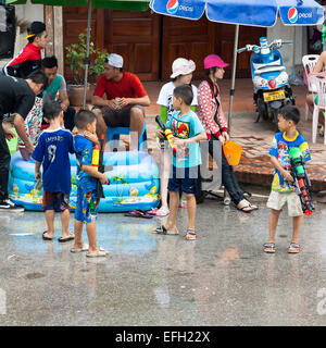 Petits garçons profiter les gens avec canon à eau pendant la célébration du Nouvel An Lao et fête de l'eau dans la région de Luang Prabang. Banque D'Images