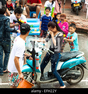 Petits garçons profiter les gens avec canon à eau pendant la célébration du Nouvel An Lao et fête de l'eau dans la région de Luang Prabang. Banque D'Images