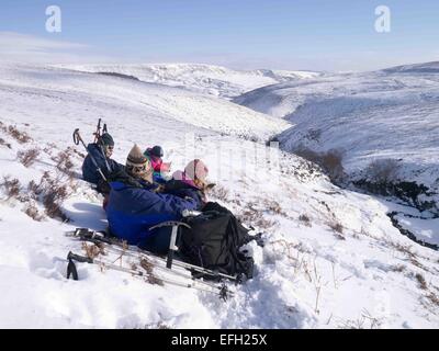 Une belle journée dans l'hivers Parc national de Peak District, Derbyshire, Royaume-Uni. Un groupe de marcheurs grimper à l'Fairbrook Kinder du Scoutisme et de retour vers le bas du plateau  ? Fairbrook Banque D'Images