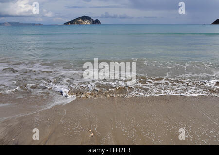 Éclaboussures des vagues sur la plage de sable de Kalamaki Zakynthos Grèce et Marathonisi habitat naturel de l'île de la tortue de mer caretta-caretta Banque D'Images