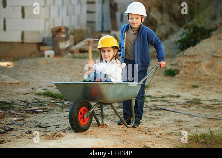 Boy and girl playing on construction site Banque D'Images