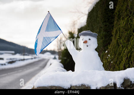 Bonhomme de neige sur un mur tenant un drapeau écossais. L'Ecosse Banque D'Images