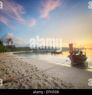 Belle image de coucher de soleil avec ciel coloré et Longtail boat sur la mer plage tropicale. Thaïlande Banque D'Images