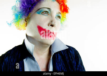 Femme vêtue de clown perruque et maquillage avec une expression triste dans ton haut Banque D'Images