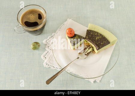 Morceau de gâteau de Pâques avec plateau décoré match ganache chocolat et doux-stuff œufs sur plaque de verre. À partir de la série dessert Banque D'Images