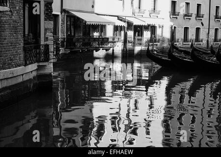 Scène vénitienne tranquille avec des réflexions et des gondoles amarrées Venise Vénétie Italie Europe Banque D'Images