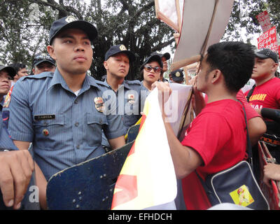 Les policiers regardent ils bloquent les manifestants de près de l'ambassade des États-Unis. Les manifestants accusé le Président Benigno Aquino III, le chef de la police suspendu Alan Purisinma, et le gouvernement des États-Unis d'être impliqués dans l'opération antiterroriste bâclé qui a tué 44 policiers, 18 commandos rebelles Moro, et 7 civils. La manifestation a eu lieu sur le 116e anniversaire de la guerre Filipino-American qui a fait au moins 600 000 morts. © Richard James Mendoza/Pacific Press/Alamy Live News Banque D'Images