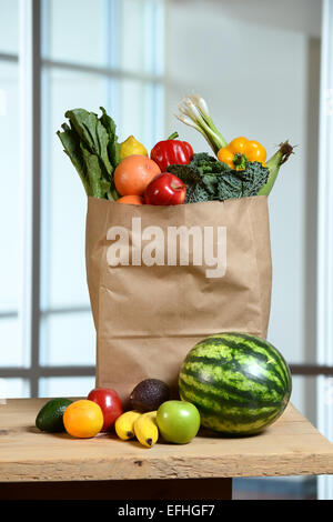 Fruits et légumes dans un sac d'épicerie et on wooden table Banque D'Images