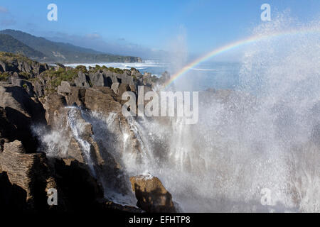 Dans l'arc-en-ciel les embruns sur pancake rocks, calcaire, dolomite, Punakaiki Point, Mer de Tasmanie, île du Sud, Nouvelle-Zélande Banque D'Images