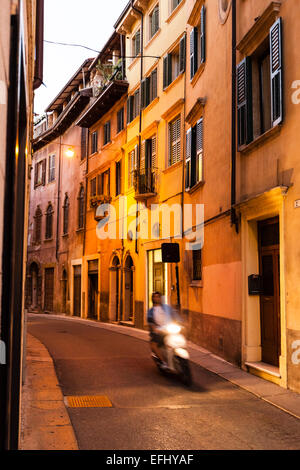 Scooter passant d'une ruelle dans le centre historique, Vérone, Vénétie, Italie Banque D'Images