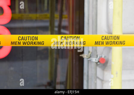 Attention Les hommes travaillant à bande jaune d'avertissement Banque D'Images
