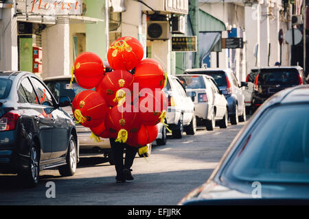 Homme portant des lanternes chinoises pour être installé dans la rue pour le festival du Nouvel an chinois Banque D'Images