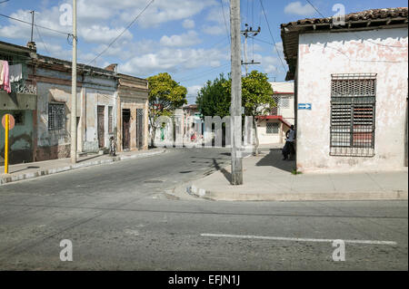 Coin de rue résidentielle avec toit plat, maisons en stuc patiné une façon street, flèche et locaux cubains sur trottoir, Cienfuegos, Cuba. Banque D'Images