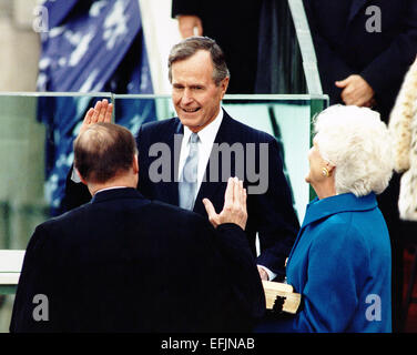 Le président américain George H. W. Bush a prêté serment pour devenir le 41e président des États-Unis au cours d'une cérémonie sur les marches du Capitole, le 20 janvier 1989 à Washington, DC. Femme Barbara détient deux bibles : un utilisé par George Washington lors de sa première inauguration en 1789 prêté par St. John's Lodge No 1 de la Libre et accepté les maçons de la ville de New York. L'autre Bible était un cadeau pour le président élu de la Chambre et du Sénat Groupe de prière. Chacune des Bibles était ouvert à la béatitude. Banque D'Images