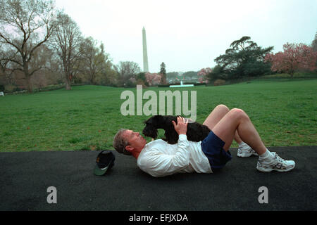 Le président américain George W. Bush fixe sur la piste de jogging de jouer avec son chien Barney après être allé courir sur la pelouse Sud de la Maison Blanche le 10 avril 2001 à Washington, DC. Banque D'Images