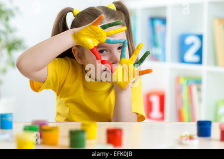 Cute kid s'amuser ses mains peinture Banque D'Images