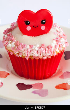Valentine anneau rouge situé sur la plaque cupcake coeur sur fond blanc - idéal pour la Saint-Valentin, jour de la Saint-Valentin Banque D'Images