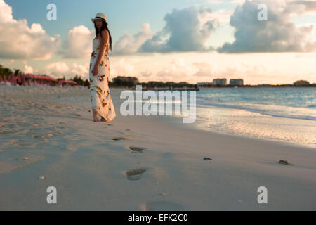 Young happy woman enjoying coucher du soleil au cours de la plage Banque D'Images