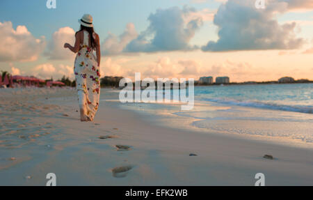 Young happy woman enjoying coucher du soleil au cours de la plage Banque D'Images