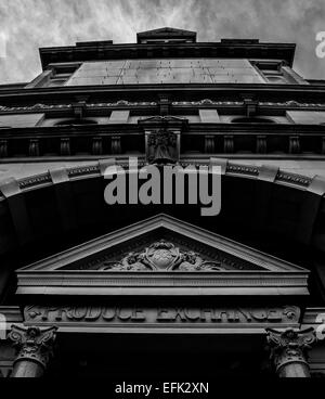 Photographie en noir et blanc d'manchester Corn Exchange à la façade en pierre jusqu'à portique et écran de télévision avec les nuages au-delà Banque D'Images