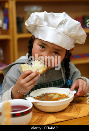 Petite fille en train de déjeuner dans un jardin d'Ulanbataar, Mongolie Banque D'Images