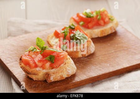 Appétissant italien simple bruschetta à la tomate et basilic, sur l'ancienne table Banque D'Images