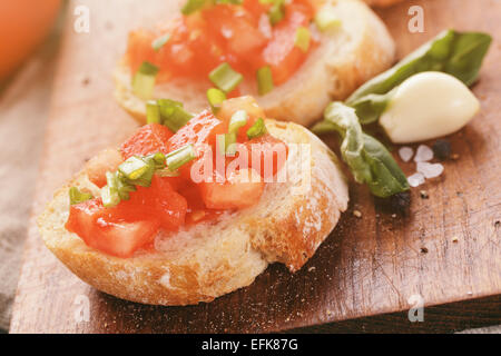 Appétissant italien simple bruschetta à la tomate et basilic, sur l'ancienne table Banque D'Images