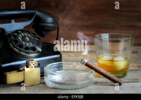 Cigare et whisky retro abstrait nature morte au téléphone sur la table Banque D'Images