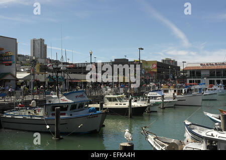 Vue du ciel bleu, de personnes et de boutiques le long de Jefferson Street, pêche sportive bateaux amarrés marina, Fisherman's Wharf, San Francisco Banque D'Images