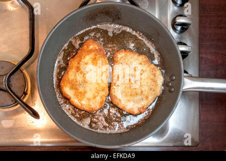 La préparation de porc - escalope escalopes de friture dans l'huile chaude pendant 3-4 minutes de chaque côté, en les retournant une fois jusqu'au brun d'or Banque D'Images