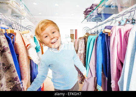 Happy blonde petit enfant se trouve entre les crochets Banque D'Images