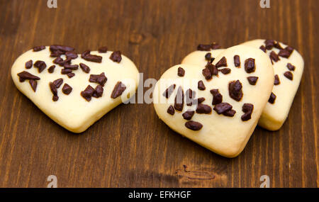 Les cookies en forme de coeur avec le chocolat sur la table en bois Banque D'Images