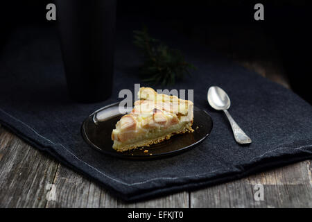 Tranche de tarte aux grands foncé tasse de thé noir sur fond noir, serviette Banque D'Images