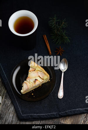 Tranche de tarte aux grands foncé tasse de thé noir sur fond noir, serviette Banque D'Images