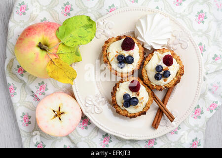 Les pâtisseries avec crème de guimauve, bleuets, framboises sur plaque vintage blanc, style shabby chic Banque D'Images