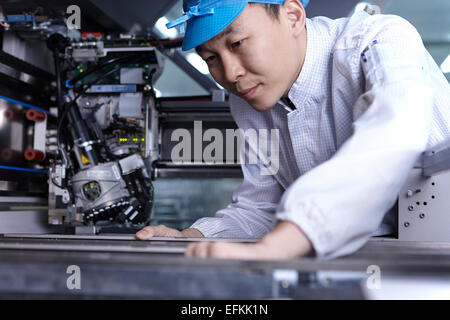 À l'aide de travailleurs en usine Machines spécialisée dans la création de circuits fonctionnels sur des surfaces souples Banque D'Images