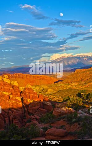 Lune s'élever au-dessus des Montagnes La Sal, avec la fournaise ardente de l'avant-plan, Arches National Park, Utah. Banque D'Images