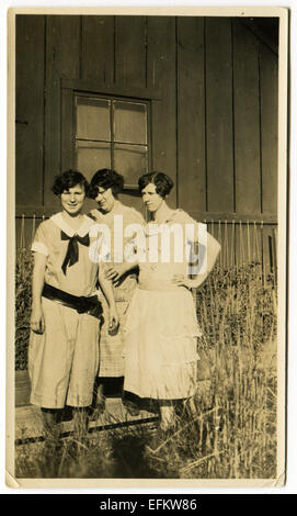 Le Canada. Dec 12, 2014. CIRCA 1930 : Reproduction d'une ancienne photo montre trois femmes en robes d'été de poser sur la toile maison de planches © Igor Golovniov/ZUMA/ZUMAPRESS.com/Alamy fil Live News Banque D'Images