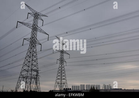 Pylônes et lignes de transport d'électricité haute tension avec réservoirs industriels sur ciel gris Toronto Banque D'Images