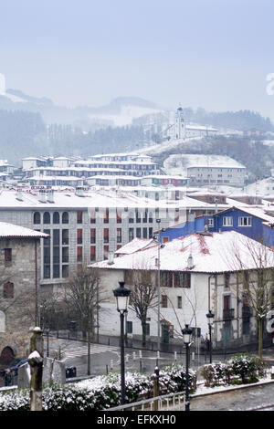 Vue panoramique sur le village d'Azkoitia en hiver avec la neige et l'église San Martin, pays Basque Banque D'Images