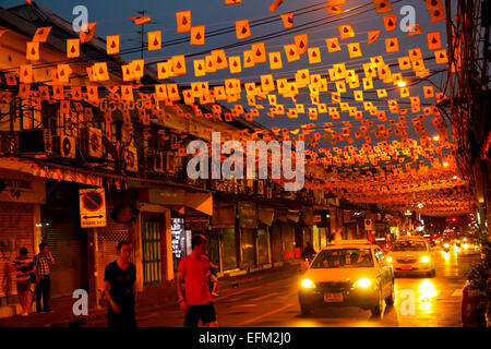 Personnes traversant une route sous les drapeaux décoratifs sur la rue Tanao dans la zone de Khaosan Road, Bangkok, Thaïlande. Banque D'Images
