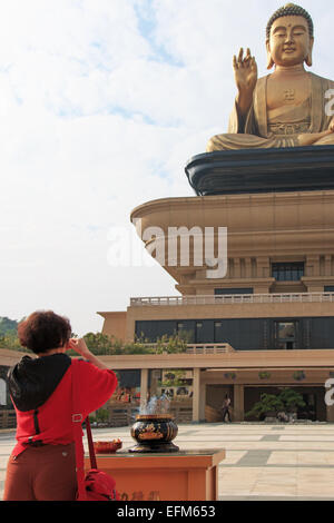 Kaohsiung, Taiwan - Décembre 15,2014 : femme qui prie le bouddha géant et de l'encens à la Fo Guang Shan de Taiwan, Kaohiun Banque D'Images