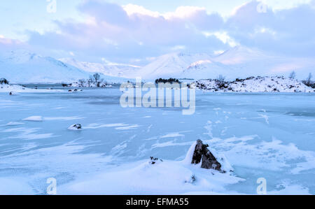 Nah Achlaise Lochan congelé sur Rannoch Moor aux pics de Blackmount en arrière-plan. Banque D'Images