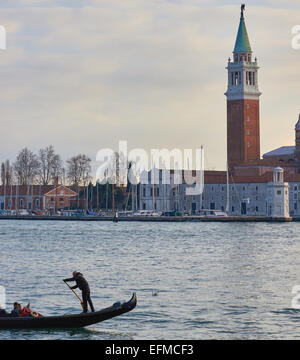 Gondolier de l'aviron sur la lagune de Venise à l'île de San Giorgio Maggiore en arrière-plan Vénétie Italie Europe Banque D'Images