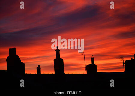 Gainford, comté de Durham, Royaume-Uni. 7e février 2015. Météo britannique. Les cheminées sont au-dessus des maisons qui se profile comme le soleil se couche à la suite d'une belle journée dans le comté de Durham. Crédit : Robert Smith/Alamy Live News Banque D'Images